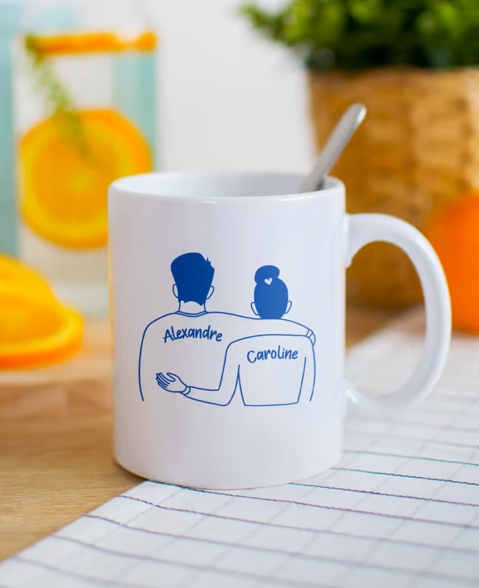 Mug personnalisé pour couple avec les prénoms Alexandre et Caroline, couleur blanc et personnages dessinés sur le mug.