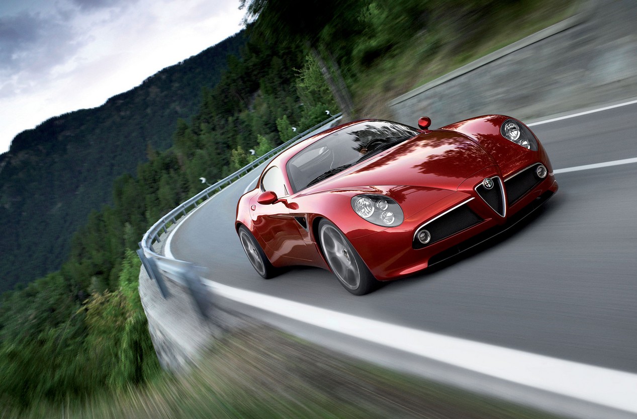 Alfa Romeo rouge modèle 8C Competizione de 2007 en train de rouler sur une route de montagne.