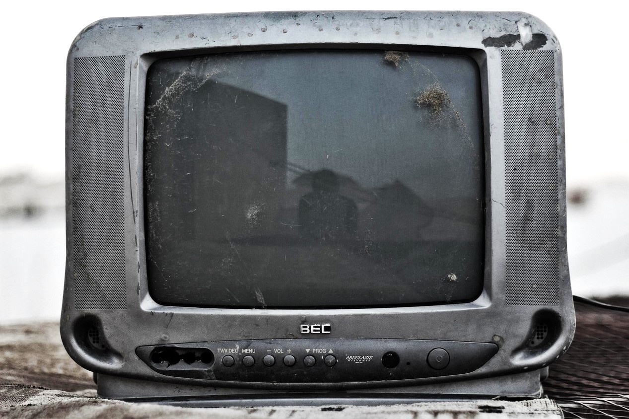 Vieux téléviseur cassé de couleur gris