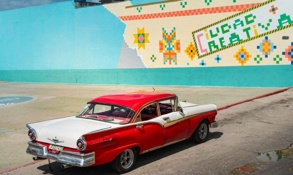 Chevrolet Bel Air 1957 couleur rouge et blanche garée face à un mur coloré