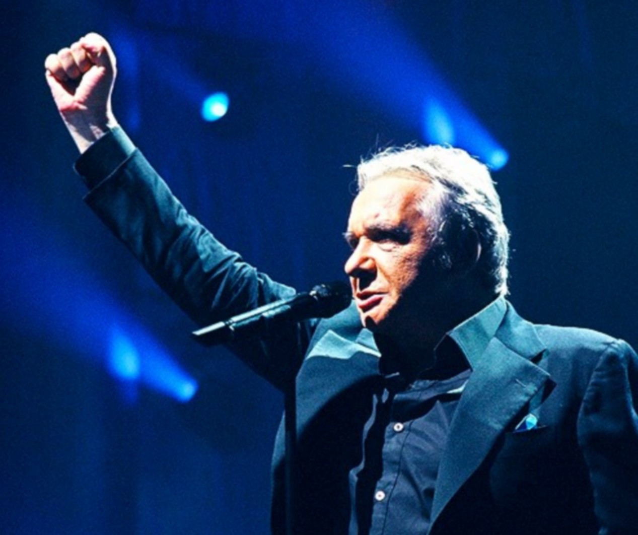 Michel Sardou en costume bleue, sur la scène du Palais des Sports de Paris, en 2005.