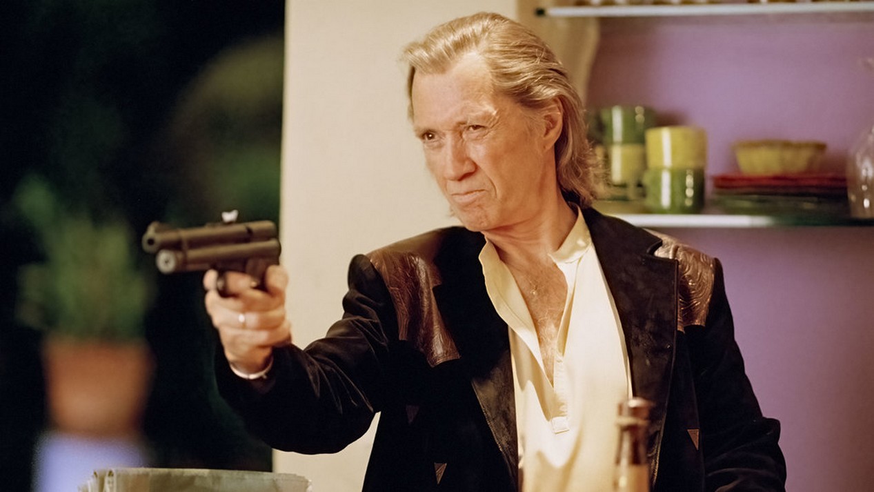 David Carradine tenant un pistolet avec fléchette endormissante dans le film KILL BILL VOLUME 2.