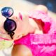Femme portant des lunettes de soleil avec un petit top rose