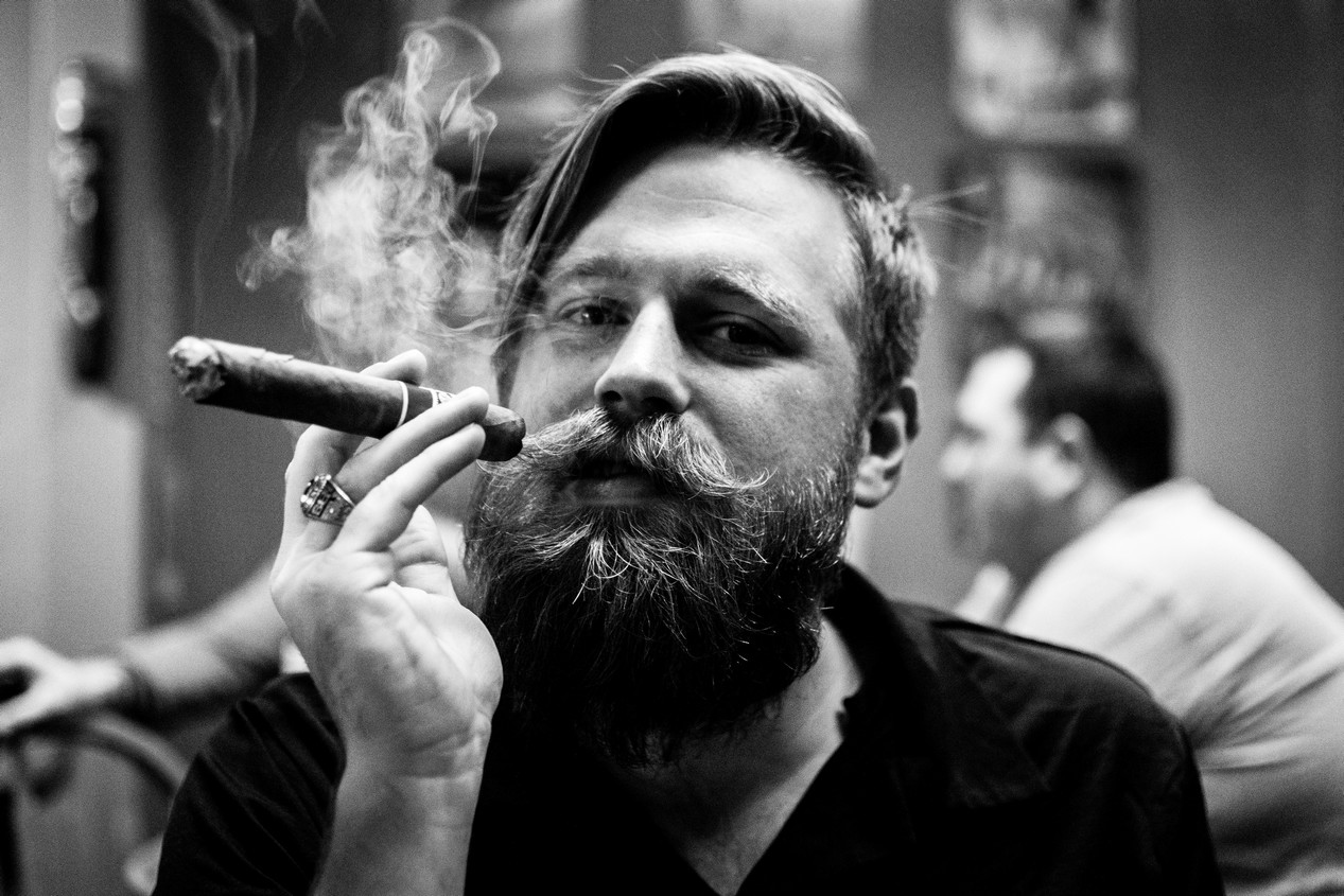 Jeune homme fumant le cigare et arborant une belle moustache vintage