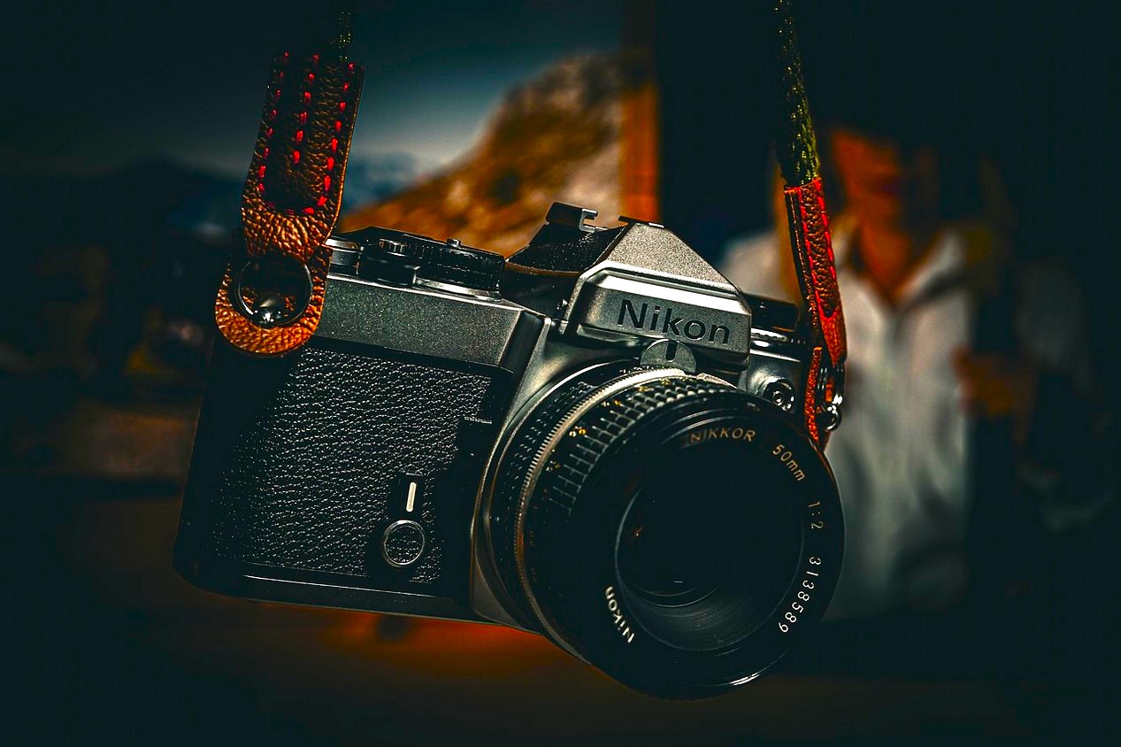 Appareil photo argentique Nikon en bandoulière