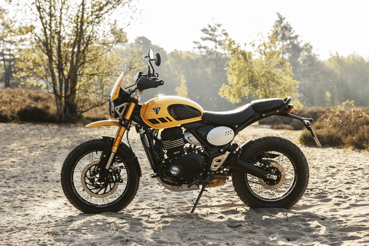 Nouvelle moto Triumph Scrambler 400 XC modèle 2026 couleur jaune posée dans le sable