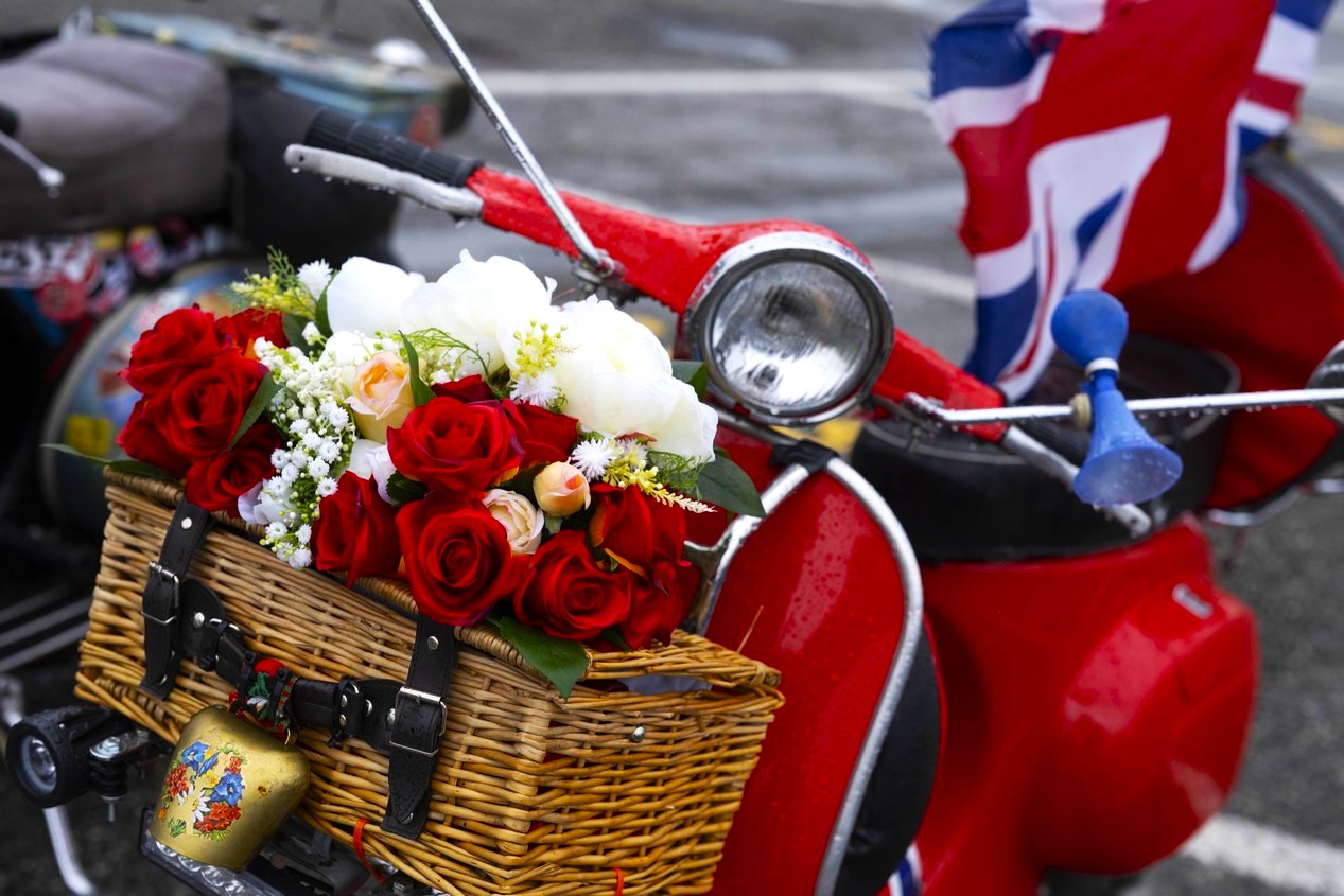 Vespa rouge avec un bouquet de roses rouges