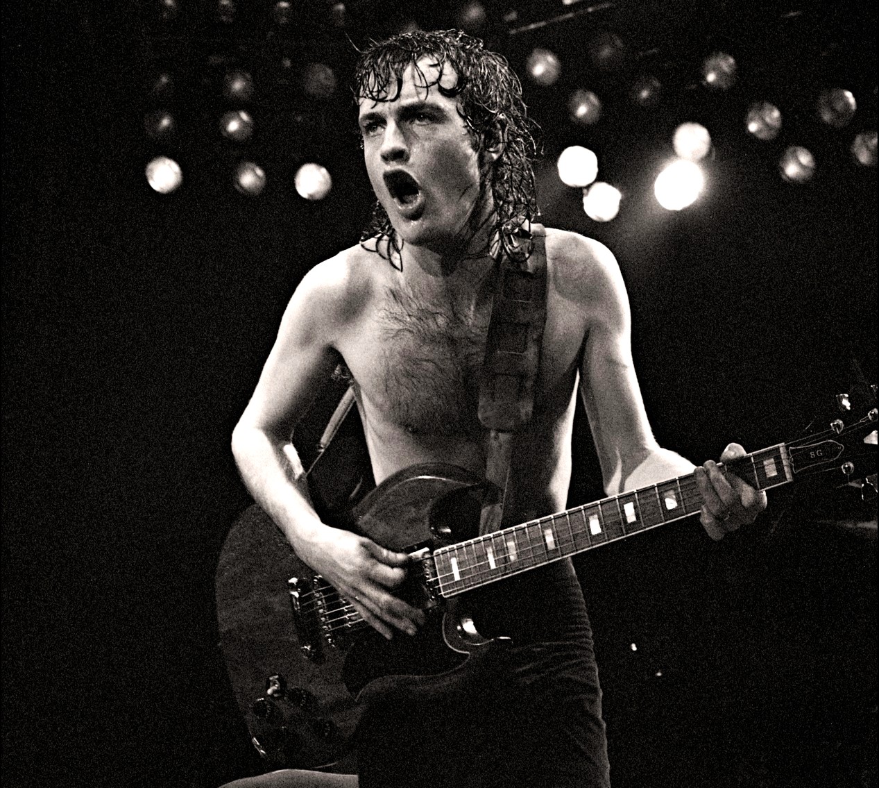 Angus Young, le co-fondateur et guitariste du groupe de rock australien AC/DC sur scène au Manchester Apollo en 1982