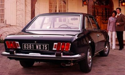Couple devant une Peugeot 504 Coupé devant une maison