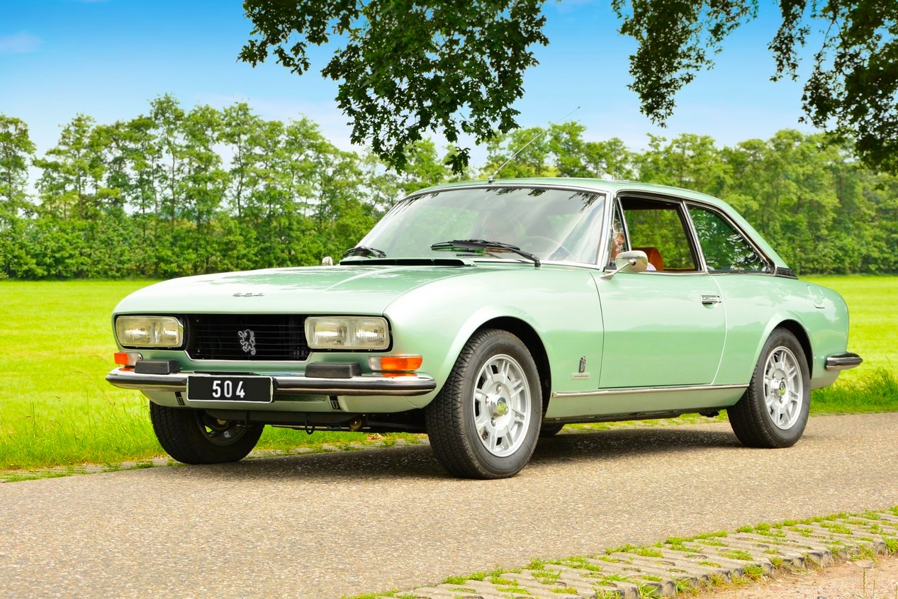 Peugeot 504 Coupé verte garée face à l'herbe