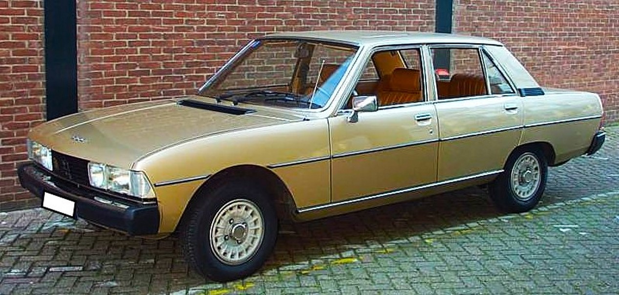 Voiture Peugeot 604 SL de 1977 garée dans la rue devant un mur de briques rouges
