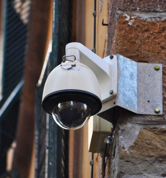 Caméra de surveillance urbaine fixée à un mur de briques rouges