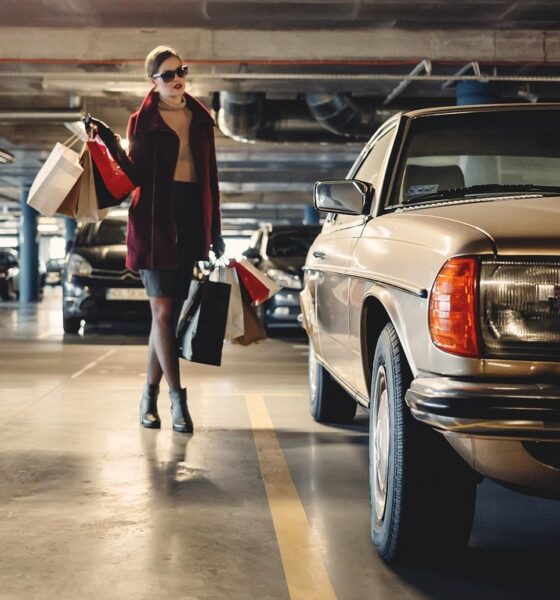 Femme élégante qui revient de son shopping et remonte dans sa voiture vintage, une vieille Mercedes