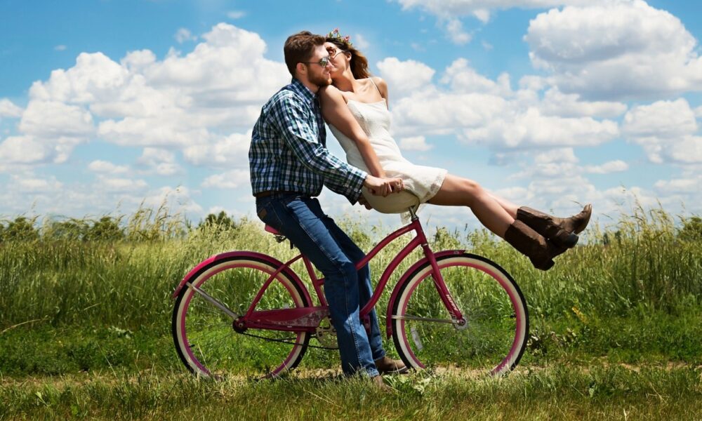 Photo en couleurs d'un couple d'amoureux en vélo dans la campagne