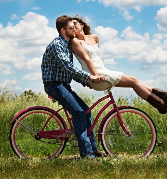 Photo en couleurs d'un couple d'amoureux en vélo dans la campagne
