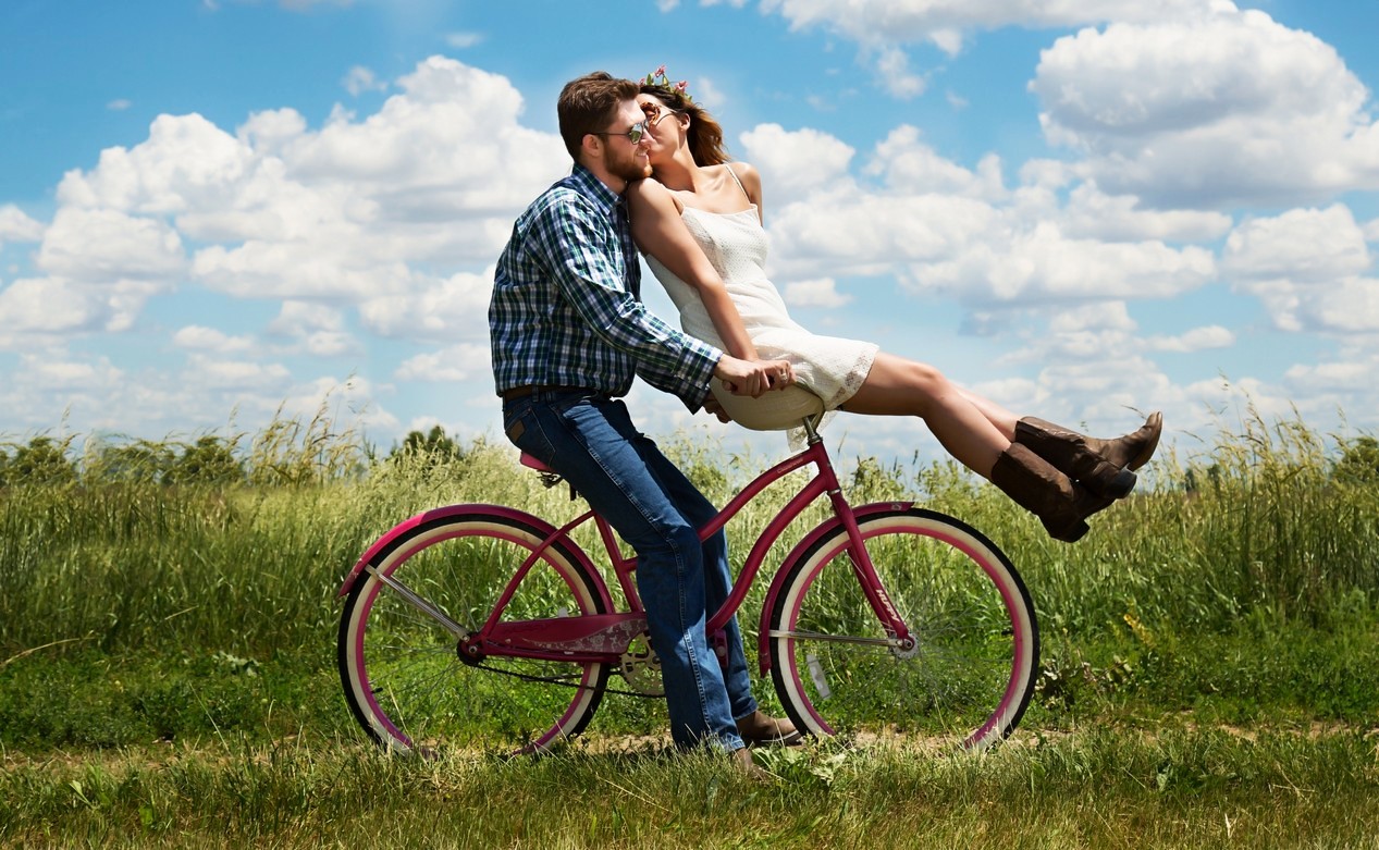 Photo en couleurs d'un couple d'amoureux en vélo dans la campagne