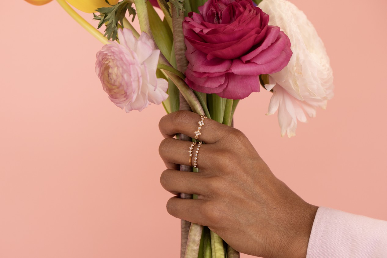 Main de femme avec des fleurs et portant des bagues