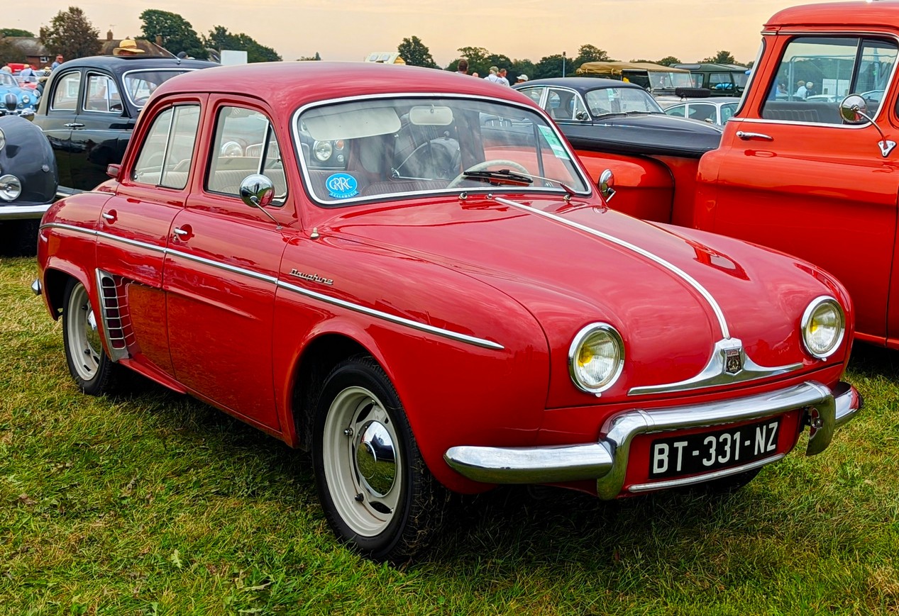 Renault Dauphine rouge stationnée sur l'herbe