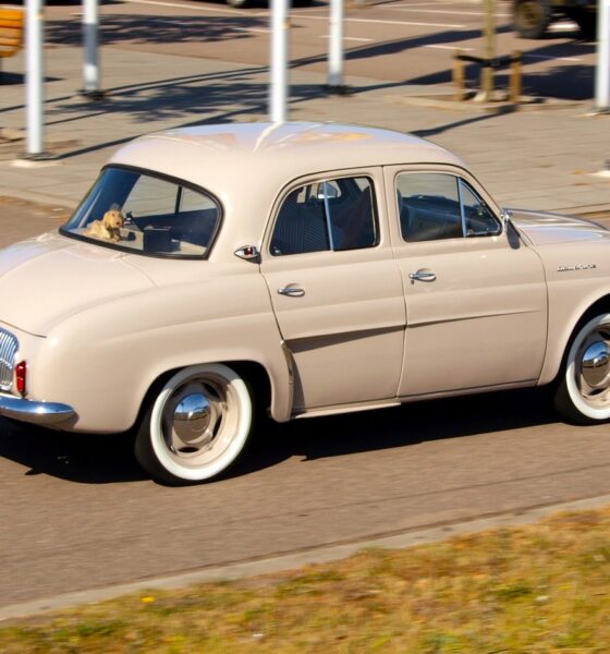 Voiture Renault Dauphine beige en train de rouler