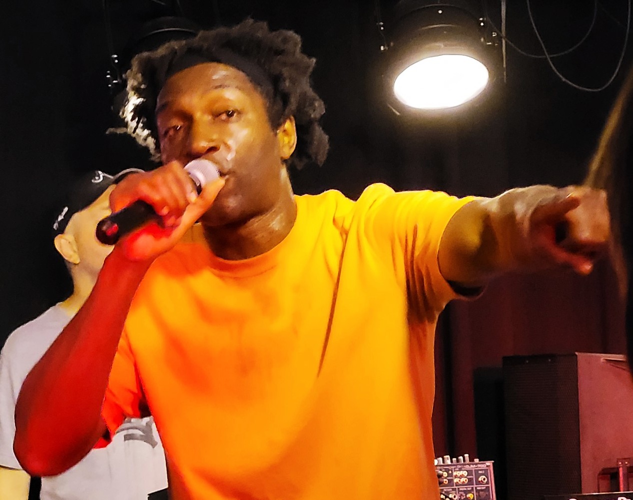 Le chanteur de rap français Kamini en concert en 2022 avec un t-shirt orange