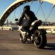 Nouvelle moto Norton Manx R modèle 2026 roulant sur un pont et de couleur grise