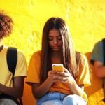 Trois jeunes en train de scroller sur leurs smartphones