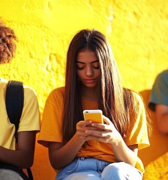 Trois jeunes en train de scroller sur leurs smartphones