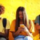 Trois jeunes en train de scroller sur leurs smartphones