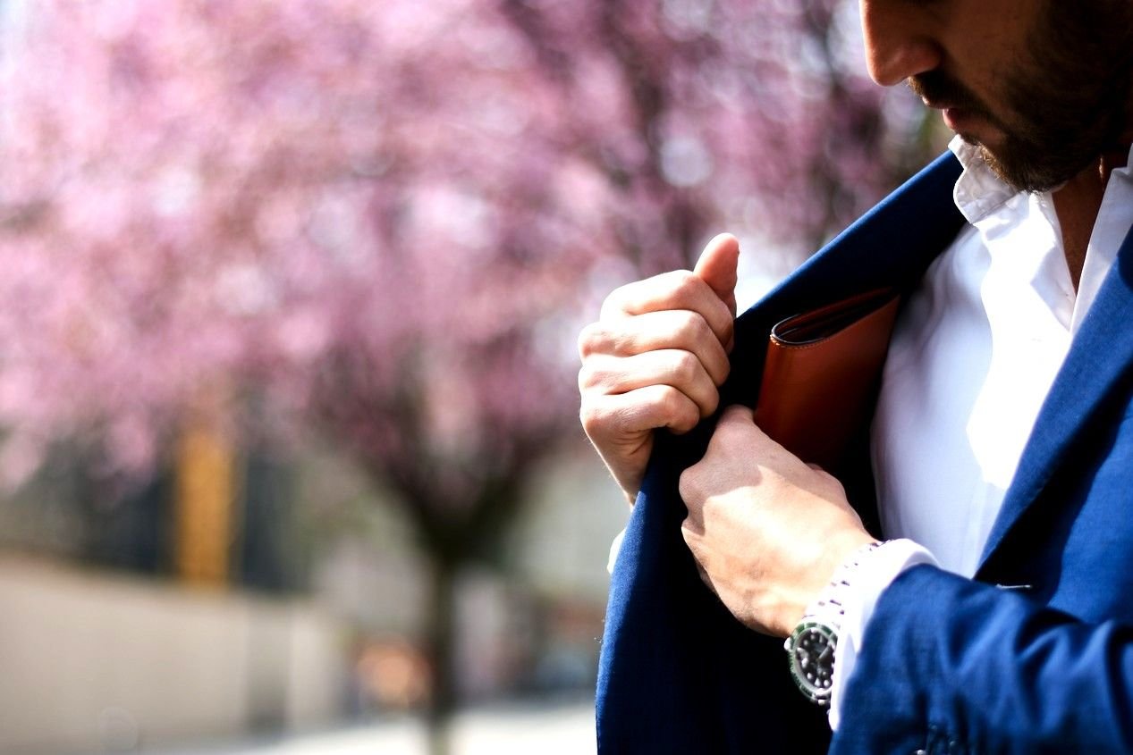 Homme qui range son portefeuille dans la poche intérieure de sa veste