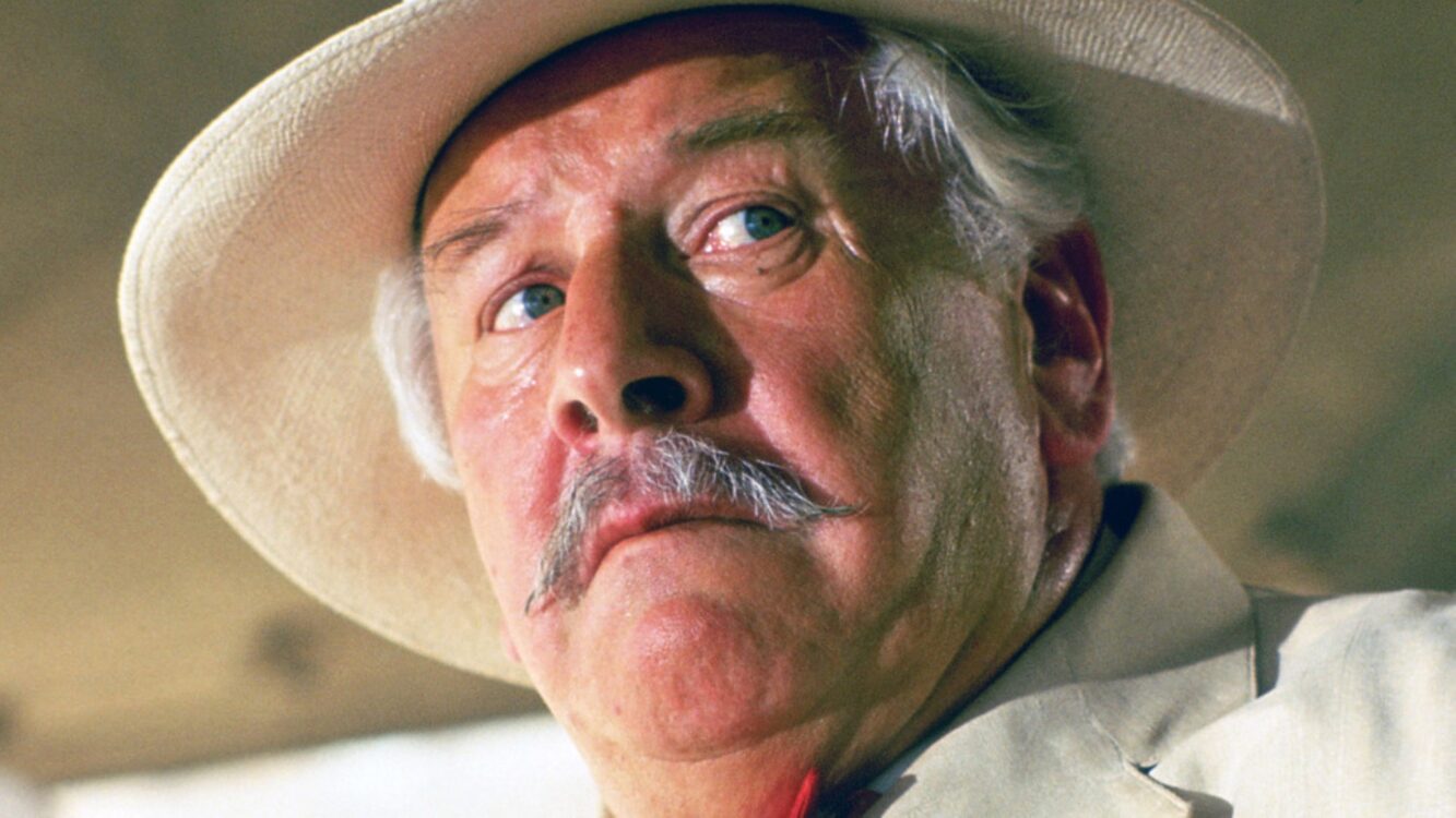 Gros plan sur le détective Hercule Poirot (Peter Ustinov) avec son chapeau clair et sa célèbre moustache.