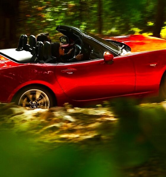 Mazda MX5 cabriolet rouge de 4ème génération modèle 2016 en train de rouler dans une forêt