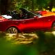 Mazda MX5 cabriolet rouge de 4ème génération modèle 2016 en train de rouler dans une forêt