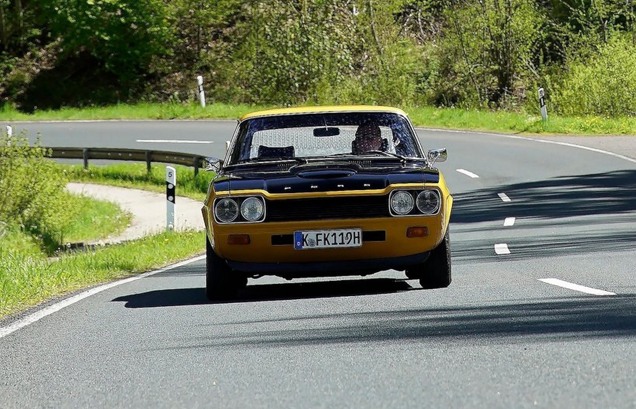 Ford Capri RS 2600 jaune et noir de 1971 en train de rouler sur une route de campagne