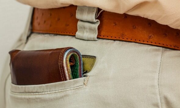 Portefeuille homme plié dans la poche arrière d'un pantalon chino