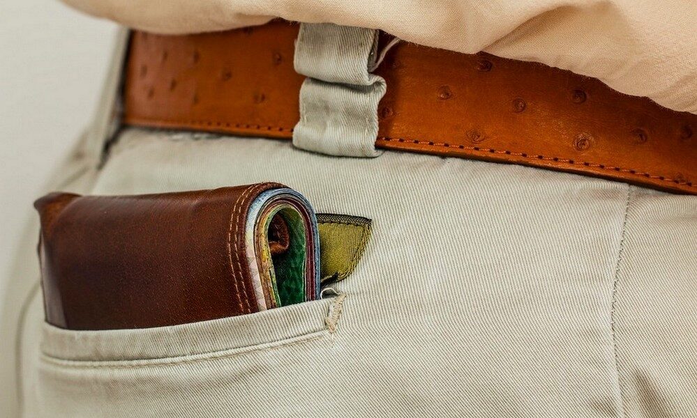 Portefeuille homme plié dans la poche arrière d'un pantalon chino
